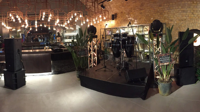 Przestrzeń wydarzeń z sceną, wyposażeniem i dekoracjami w pomieszczeniu z ceglastymi ścianami.